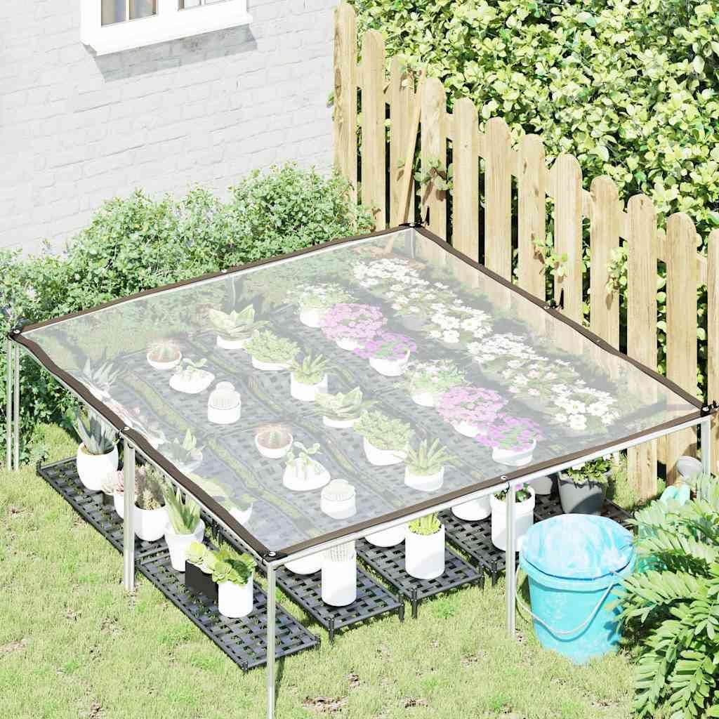A clear plastic tarp greenhouse setup in a garden with potted plants.