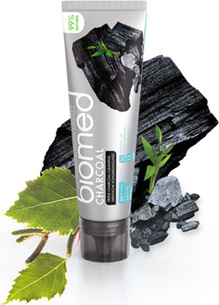 A tube of BIOMED CHARCOAL toothpaste is shown with charcoal pieces and leaves.