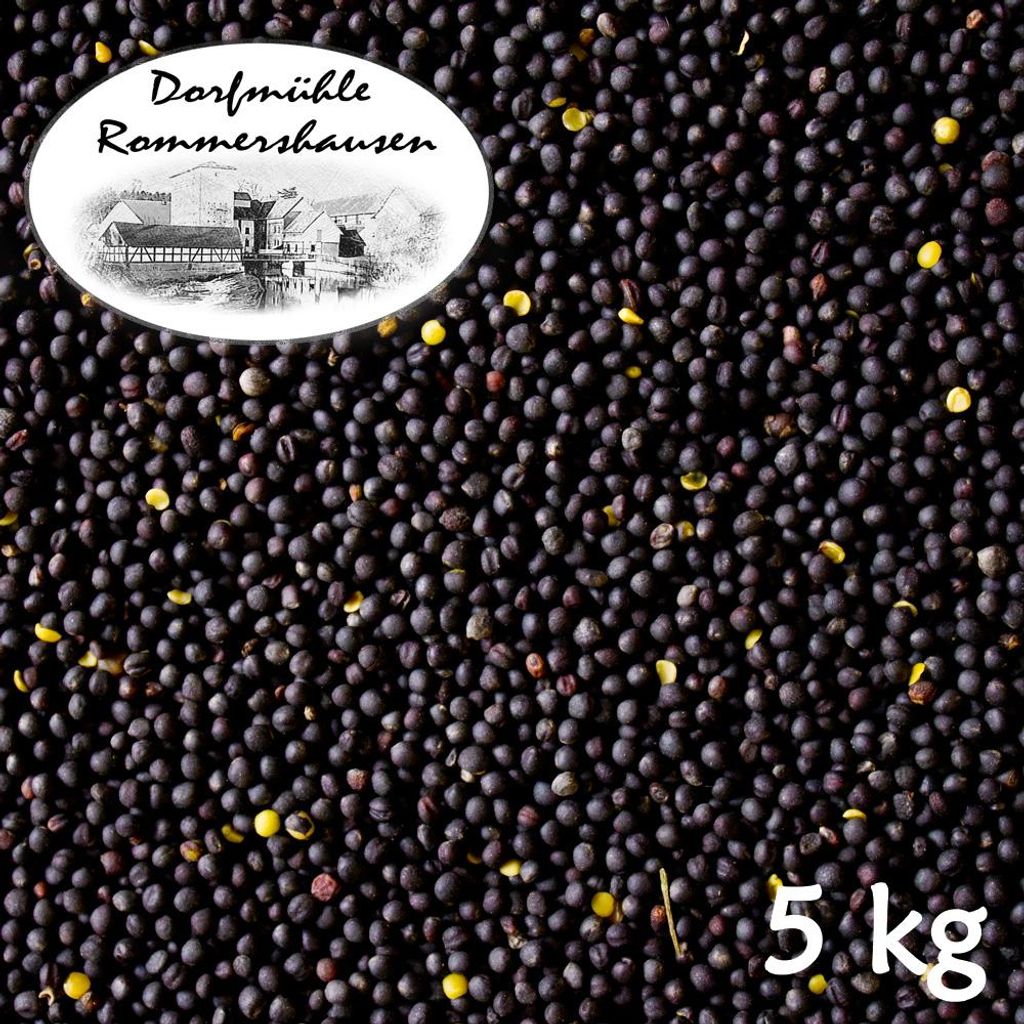 A pile of dark seeds, likely rapeseed or mustard seeds, with a white oval label in the upper left corner featuring a drawing of buildings and text, and the number '5 kg' in the bottom right corner.