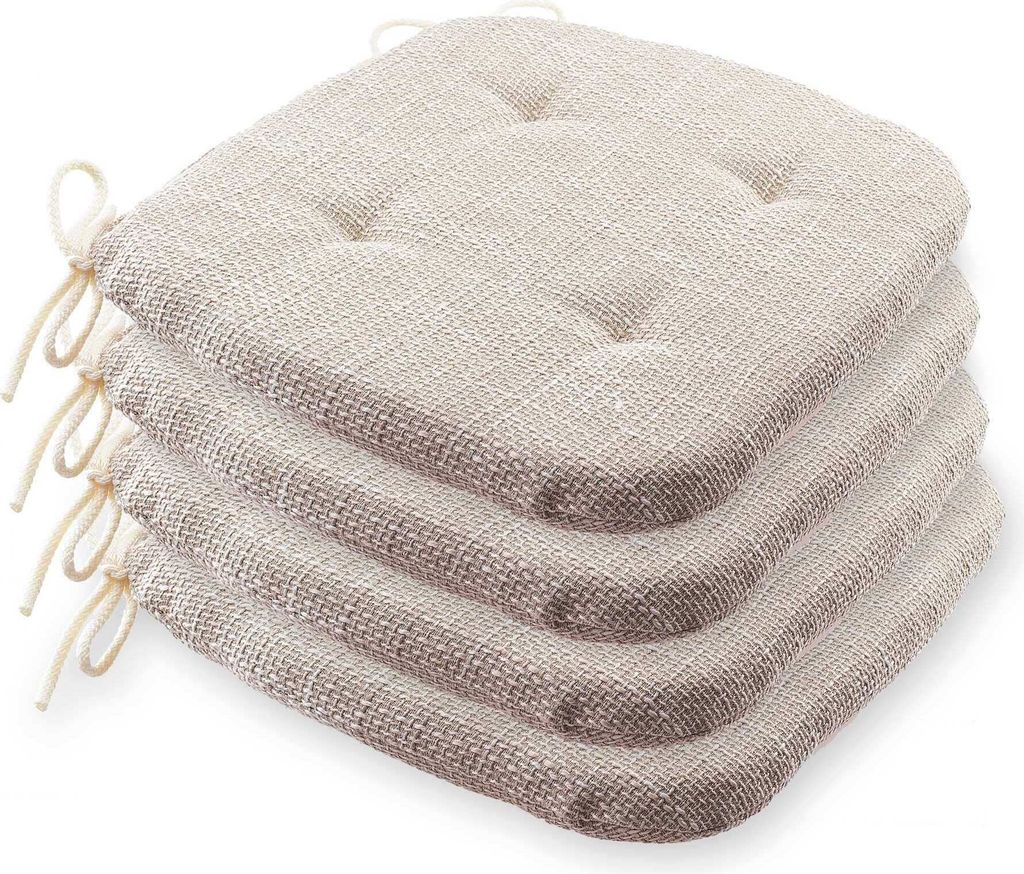 A stack of four beige seat cushions with ties.