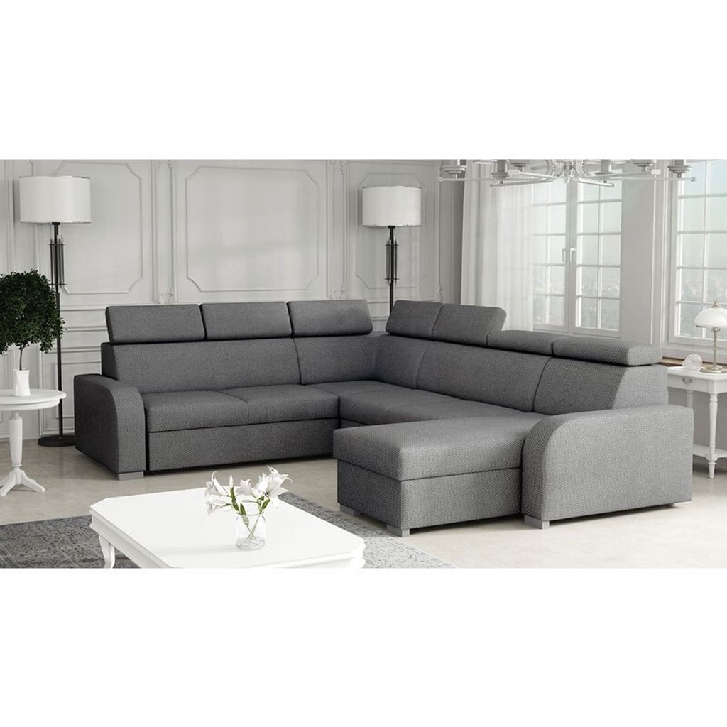 A grey sectional sofa with adjustable headrests is shown in a well-lit room with decorative molding on the walls.