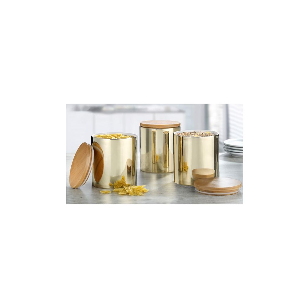 Three gold canisters with wooden lids are displayed on a countertop, with some pasta spilled in front of one.