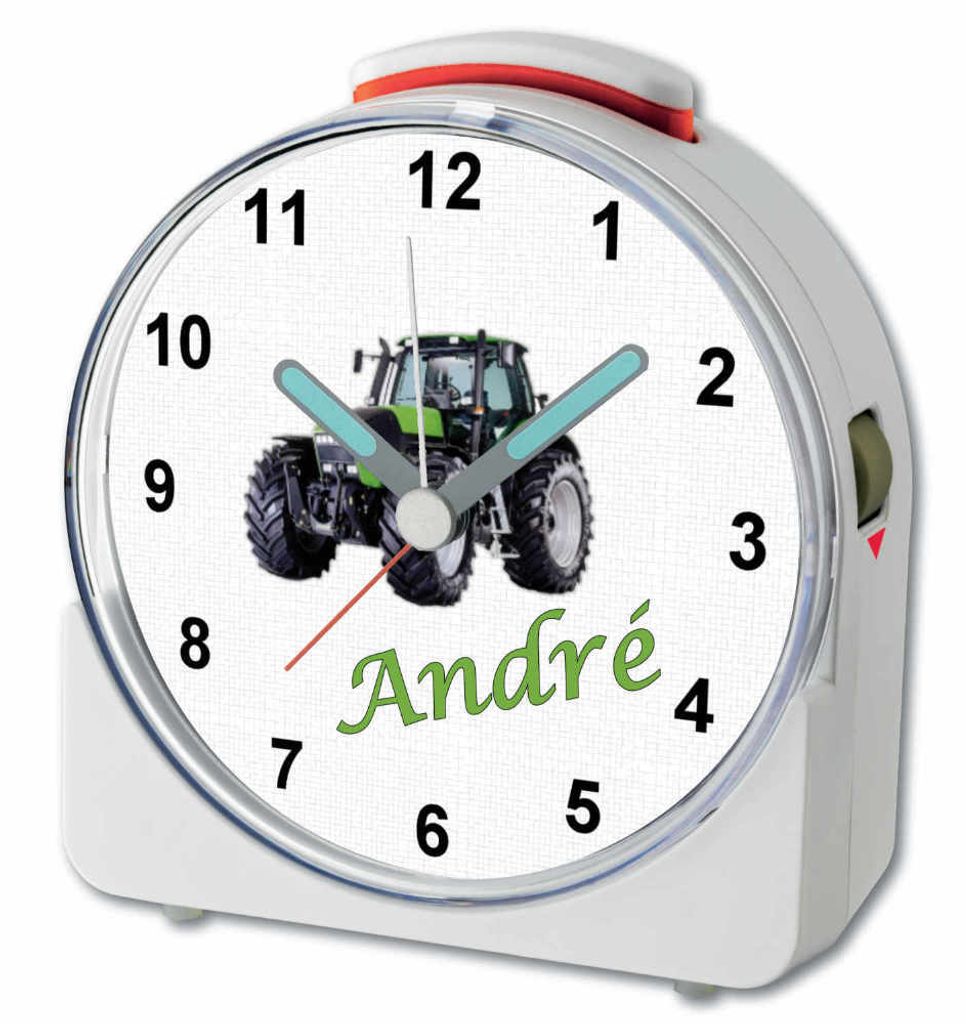 A close-up of a white alarm clock with a tractor image and the name 'André' on the face.