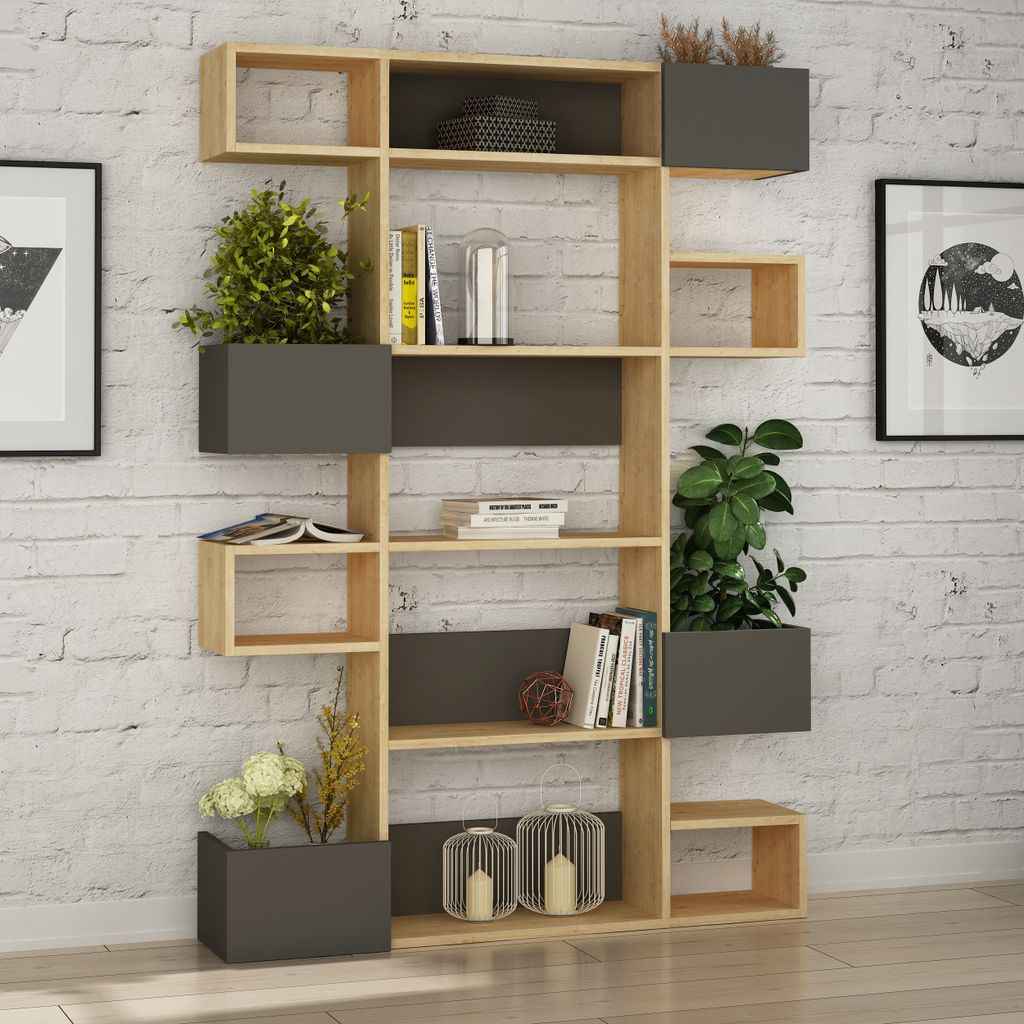 A modern bookshelf filled with books, plants, and decorative items, set against a white brick wall.