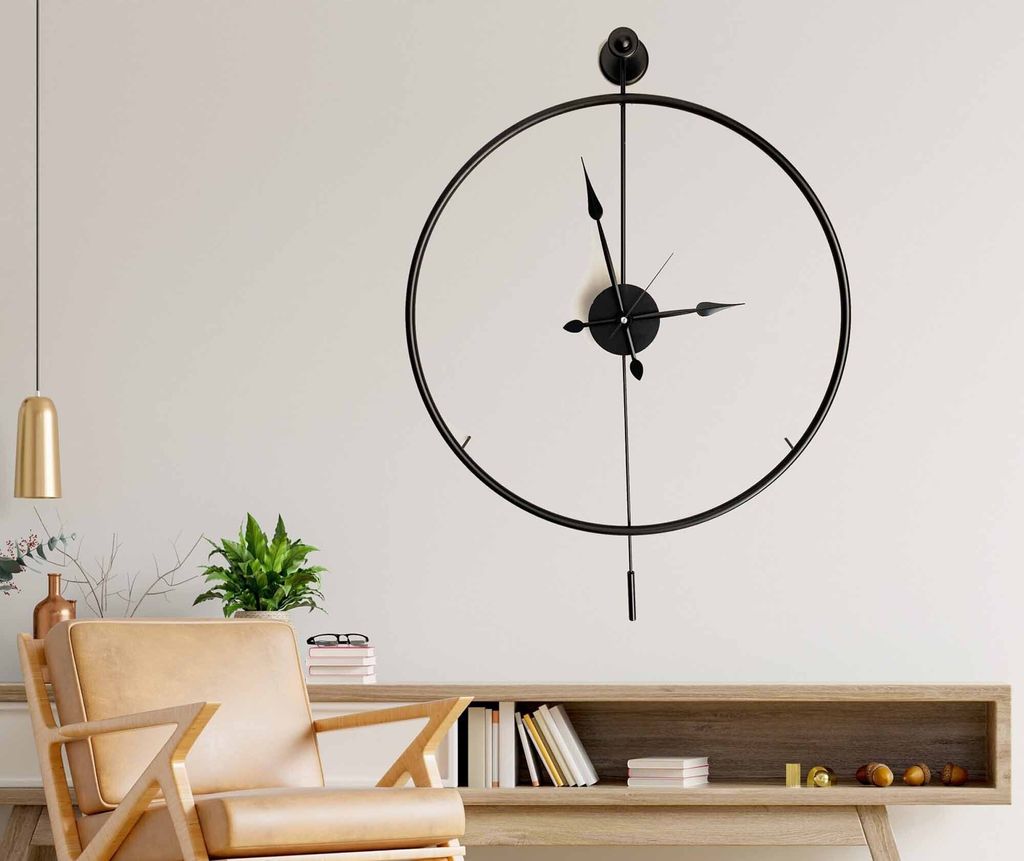 A modern living room with a large wall clock, a chair, and a console table.