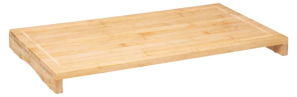 A light brown bamboo cutting board with a raised edge and legs, shown from a diagonal angle against a white background.
