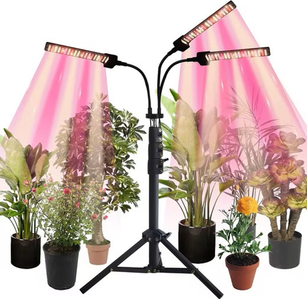 A plant grow light with multiple adjustable heads is shown illuminating several potted plants.