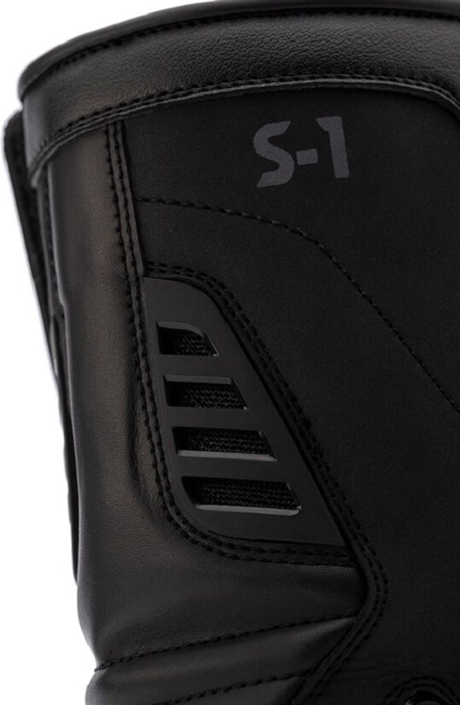 A close-up view of a black motorcycle boot.