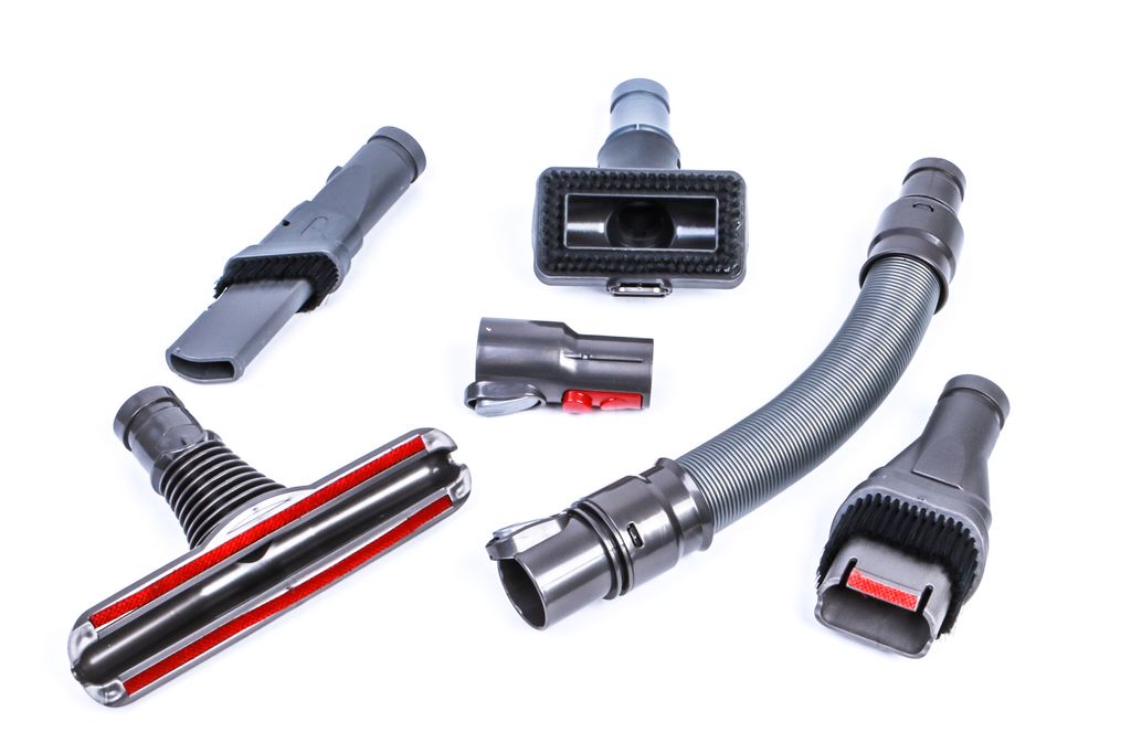 A collection of vacuum cleaner attachments laid out on a white background.