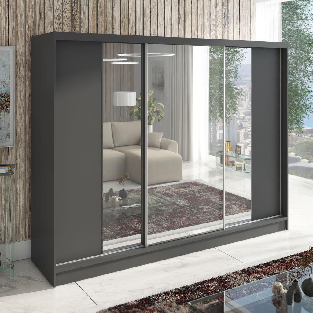 A large, modern wardrobe with mirrored sliding doors, reflecting a living room interior.