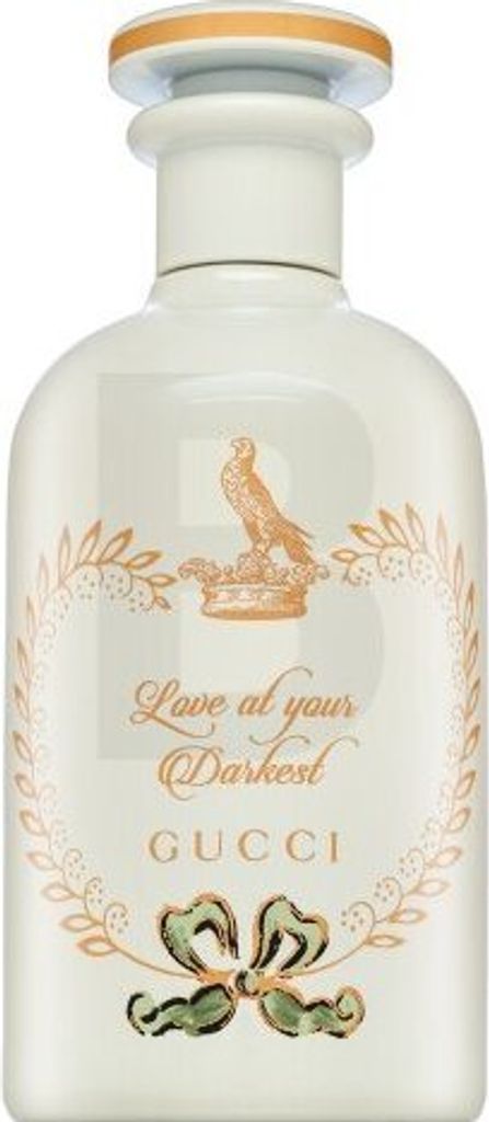 A white bottle of Gucci perfume with gold and green decorative elements.