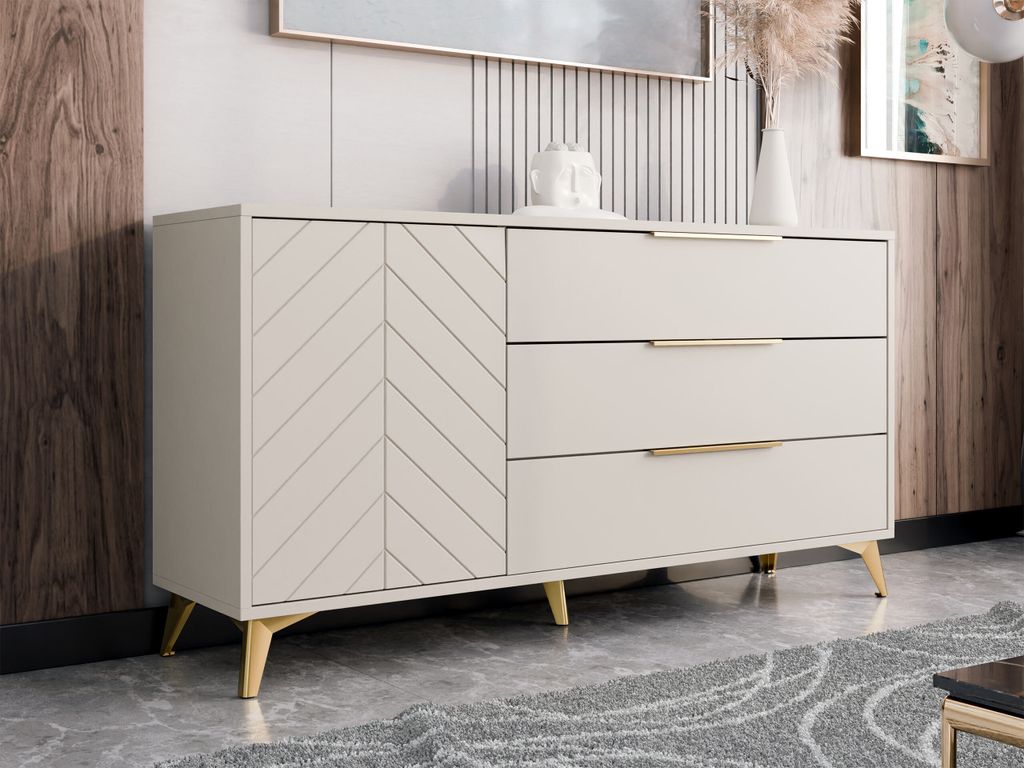 A modern sideboard with a herringbone patterned door and three drawers, set against a neutral background with wood paneling and a framed artwork.
