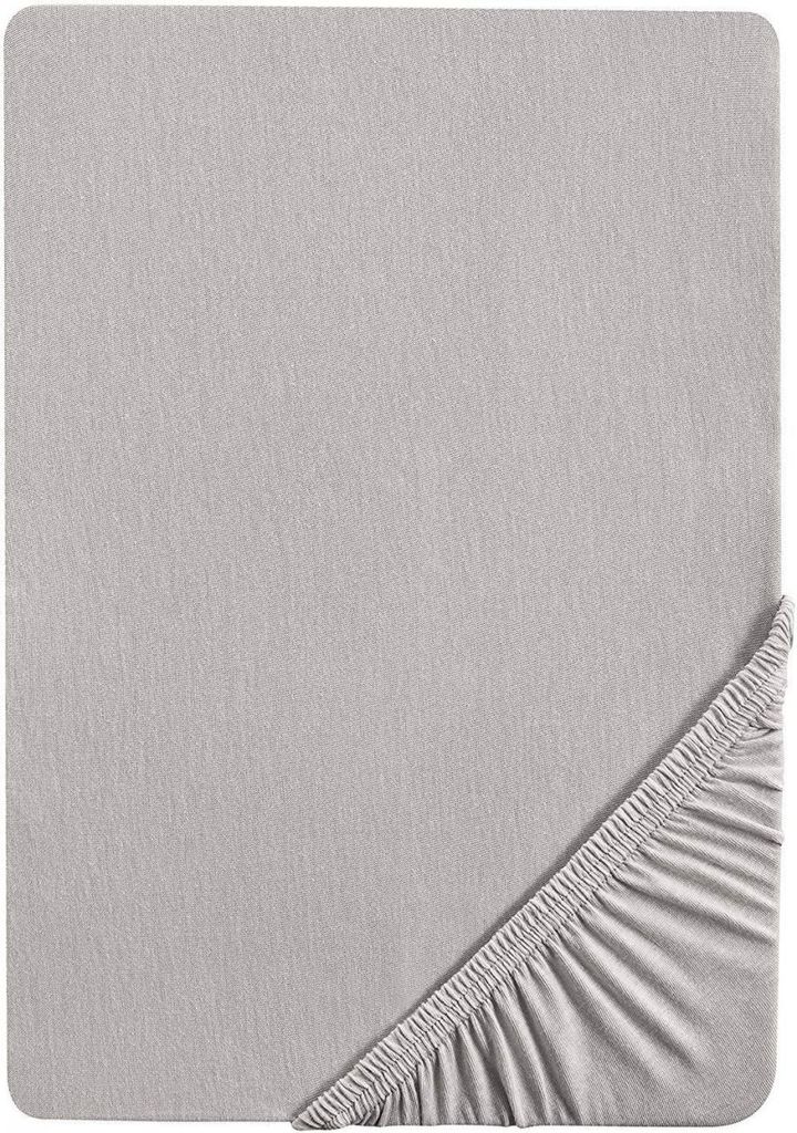 A flat lay of a grey fitted sheet, showing the texture of the fabric and the elasticated edge in the bottom right corner.