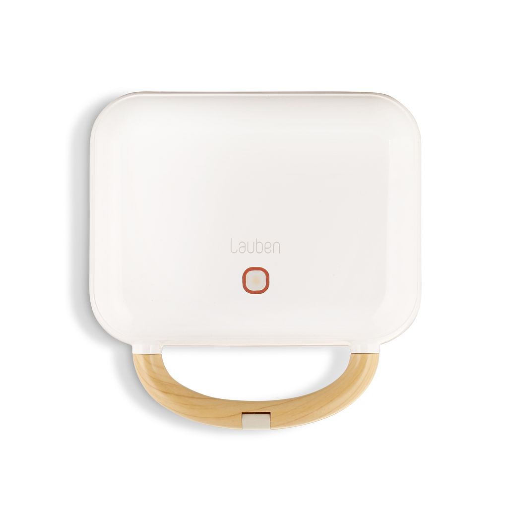 A top-down view of a white sandwich maker with a wooden handle.