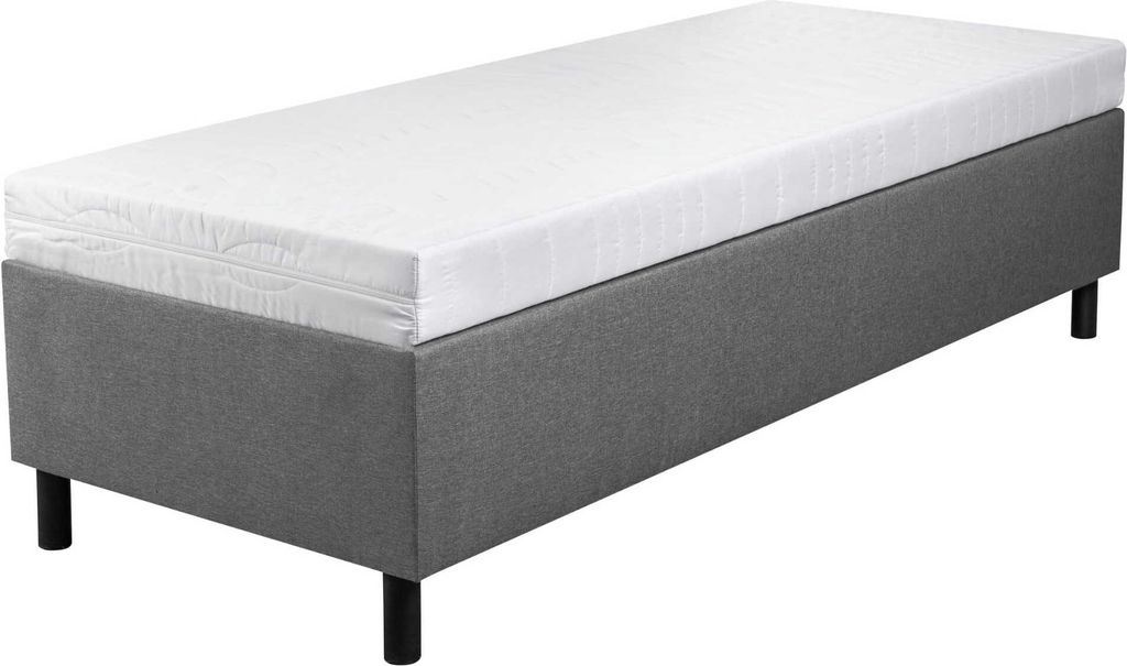 A single bed with a gray upholstered base and a white mattress on top, shown from a slightly elevated side angle against a white background.