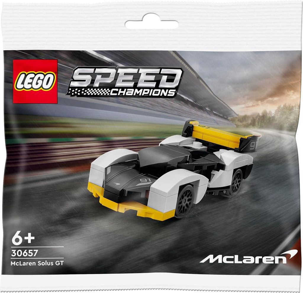 A LEGO Speed Champions McLaren Solus GT polybag on a blurred racetrack background.