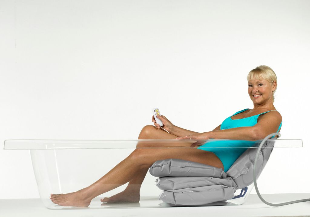 A woman is sitting in a bathtub using a bathing cushion.