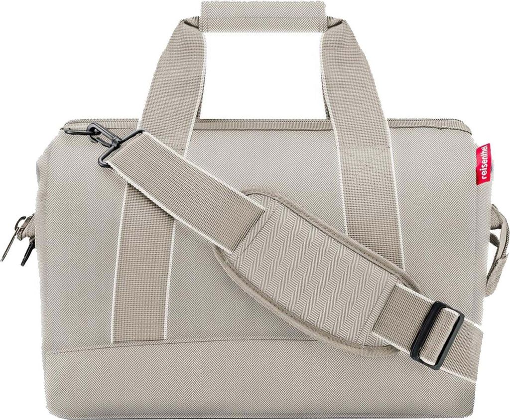 A studio shot of a beige duffel bag with a shoulder strap.