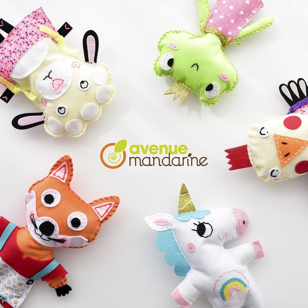 A collection of five handmade felt toys, including a fox, a unicorn, a frog, a lamb, and a bird-like creature, arranged on a white background.