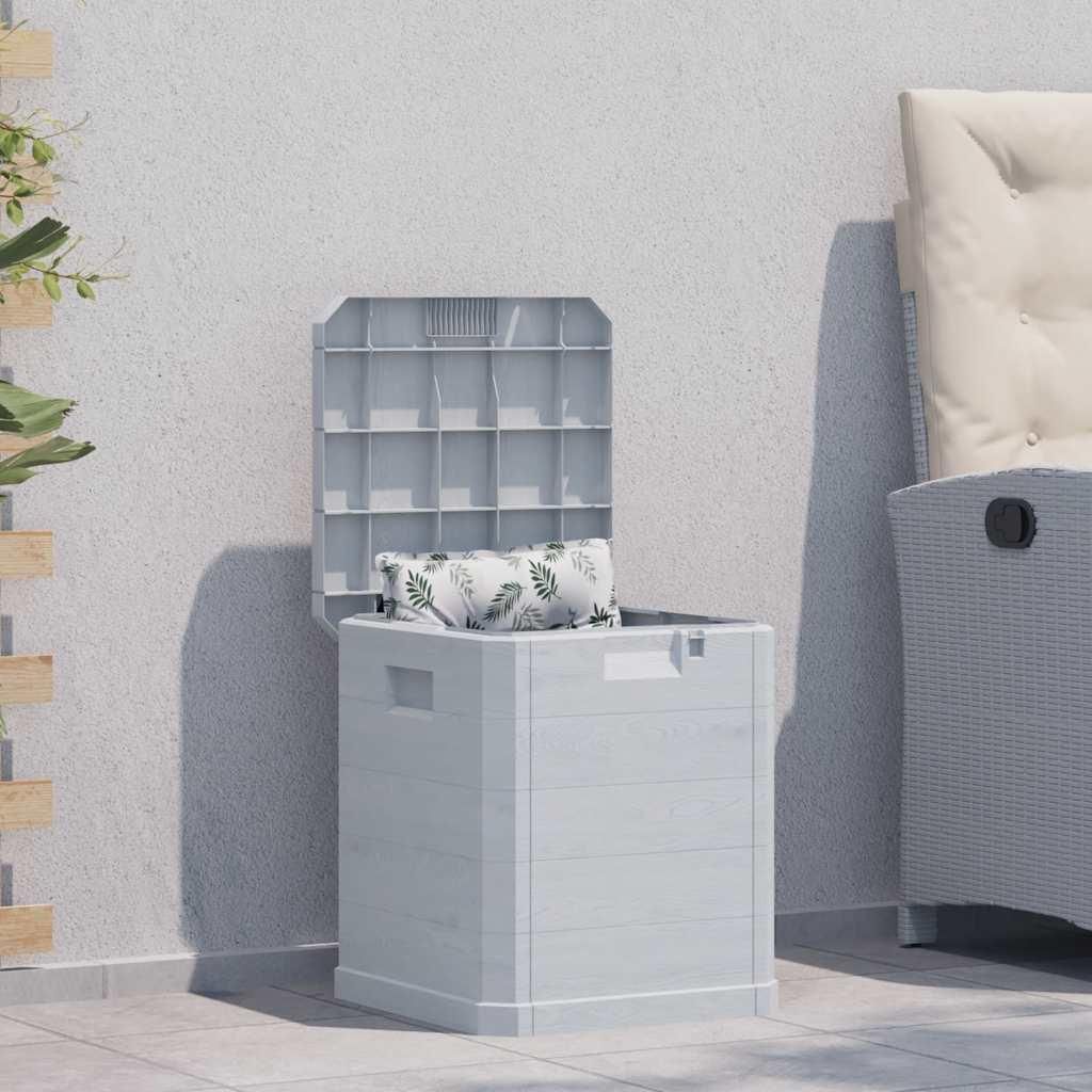 An outdoor storage box is placed on a patio next to a wall and a chair.