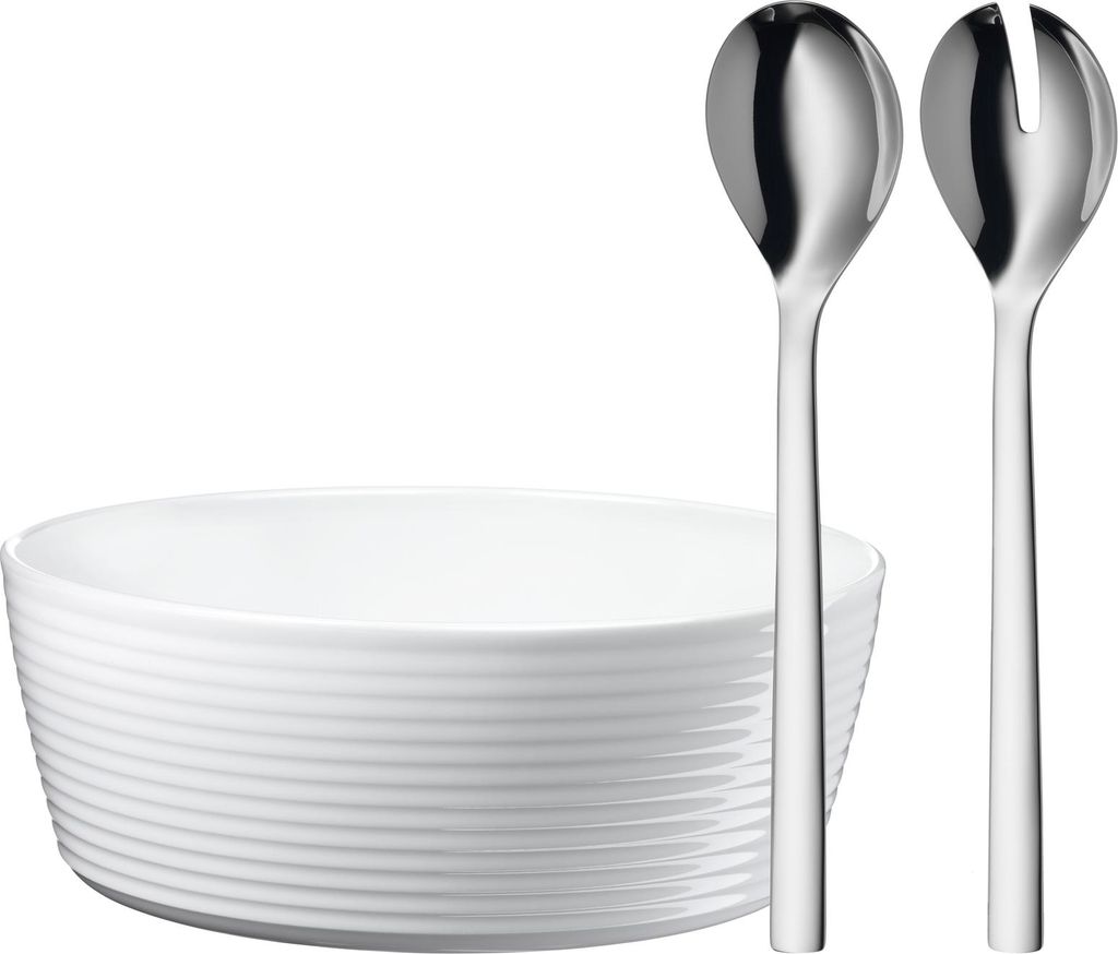 A white salad bowl with two silver serving utensils.