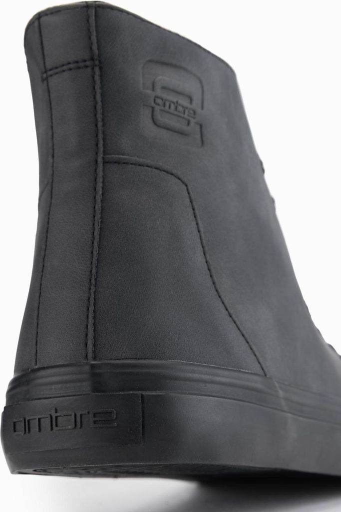 A close-up, rear view of a black boot.