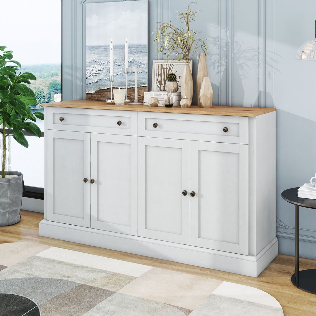 A white sideboard with a wooden top is shown in a room with a window, a plant, and decorative items on top.