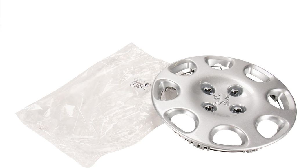 A silver Peugeot hubcap is shown next to a clear plastic bag on a white background.