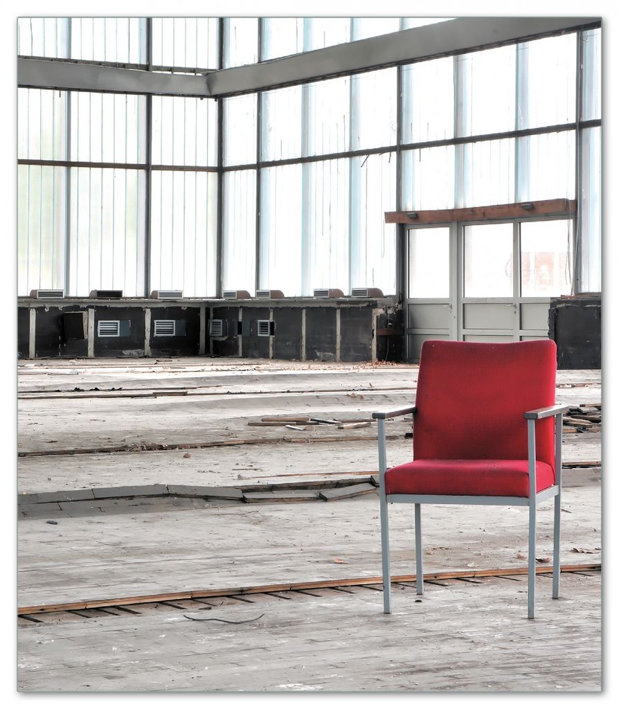 Wallario Herdabdeckplatte aus Glas, Größe 52 x 60 cm 1-teilig, Motiv Stille und Leere - ein einsamer roter Stuhl in einer alten Halle