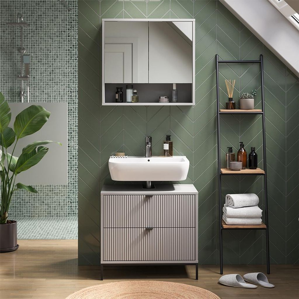 A modern bathroom with green tiled walls, a sink, vanity, and shelving unit.