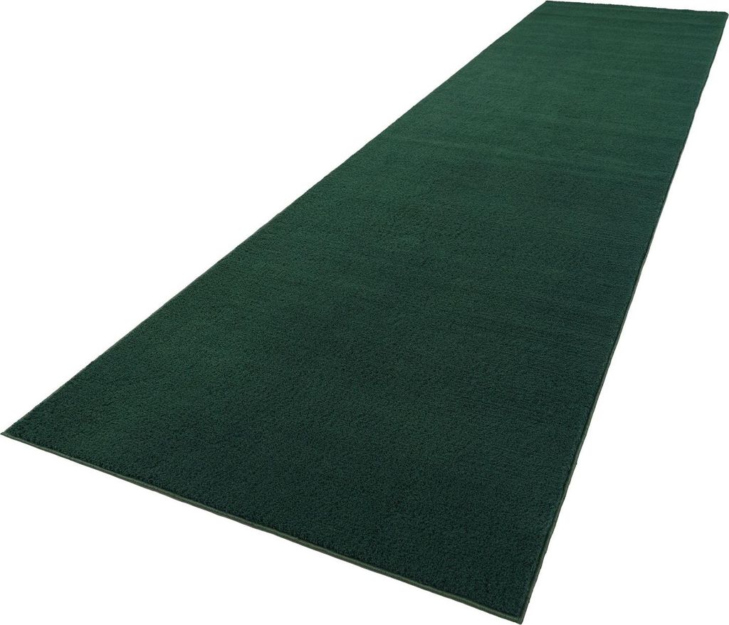 A dark green rug is shown from a diagonal angle against a white background.