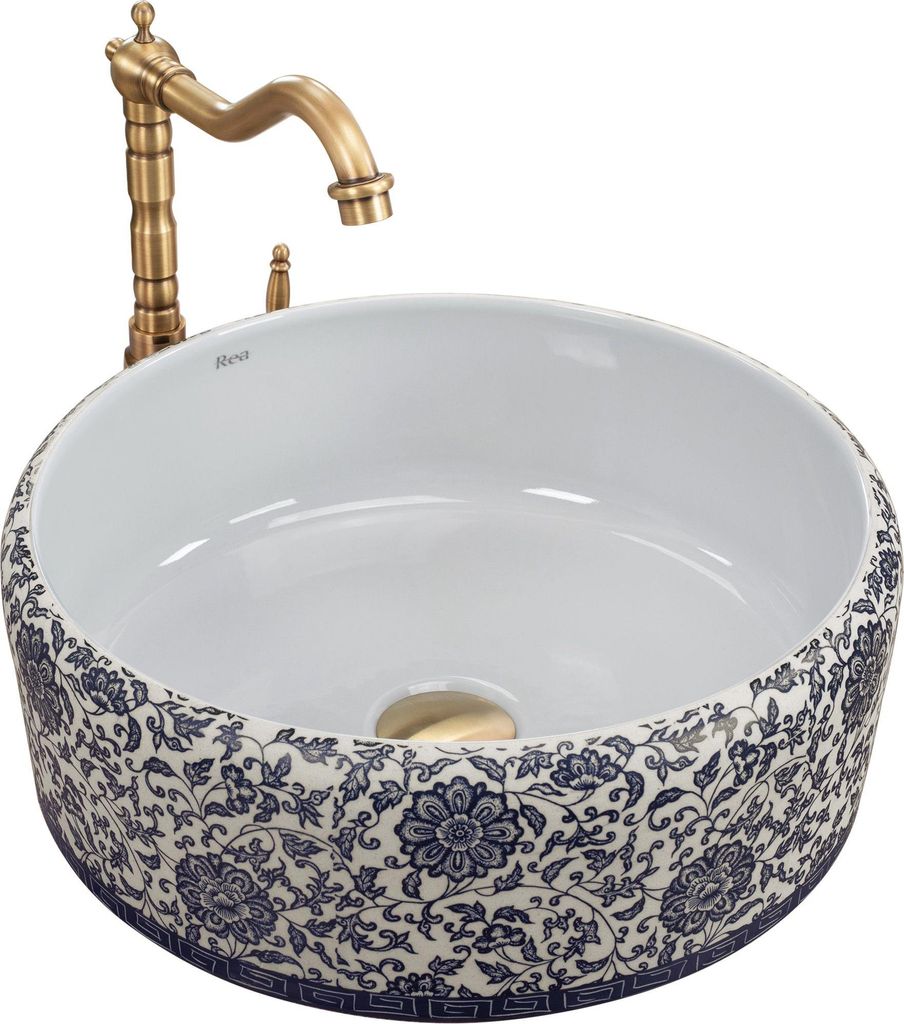 A white ceramic sink with a blue floral pattern and a gold faucet.