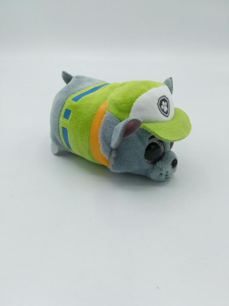 A stuffed toy dog wearing a green vest and hat, set against a white background.