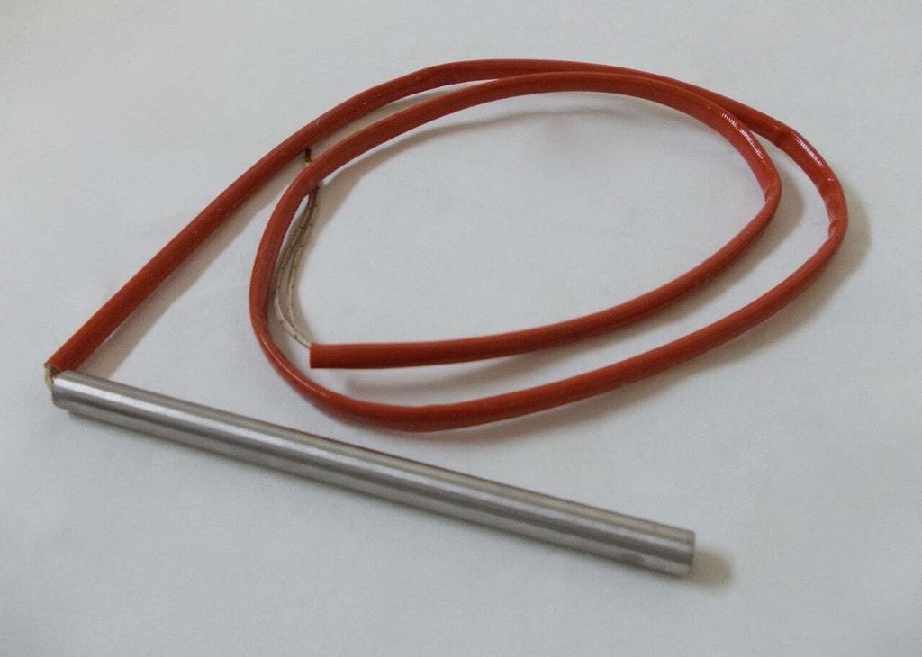 A heating element with a red insulated wire on a white background.