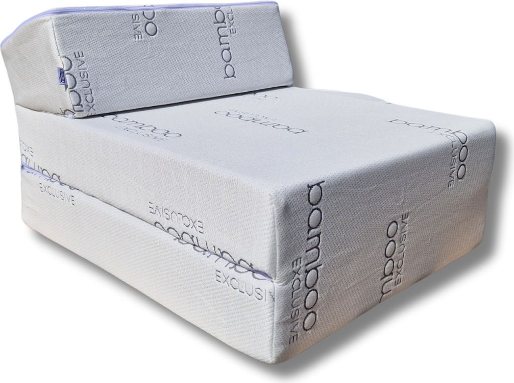 A white foldable mattress is shown in a studio setting.
