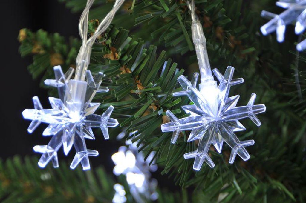 Close-up of snowflake-shaped LED lights on a Christmas tree.
