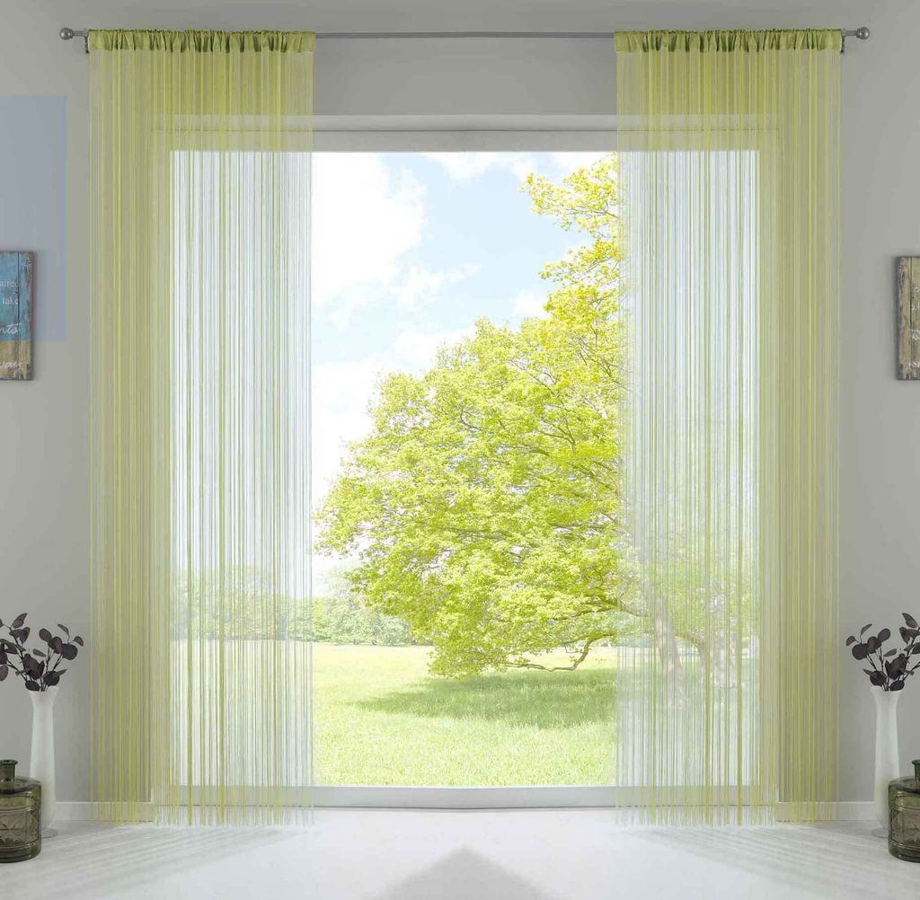 A window with light green string curtains, showing a sunny outdoor scene with a large tree.