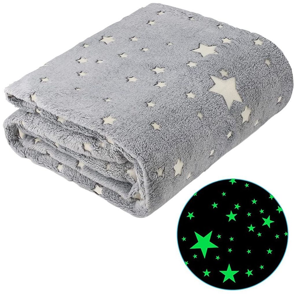 A folded grey blanket with white stars is shown against a white background. A circular inset shows a close-up of the blanket's pattern glowing green in the dark.