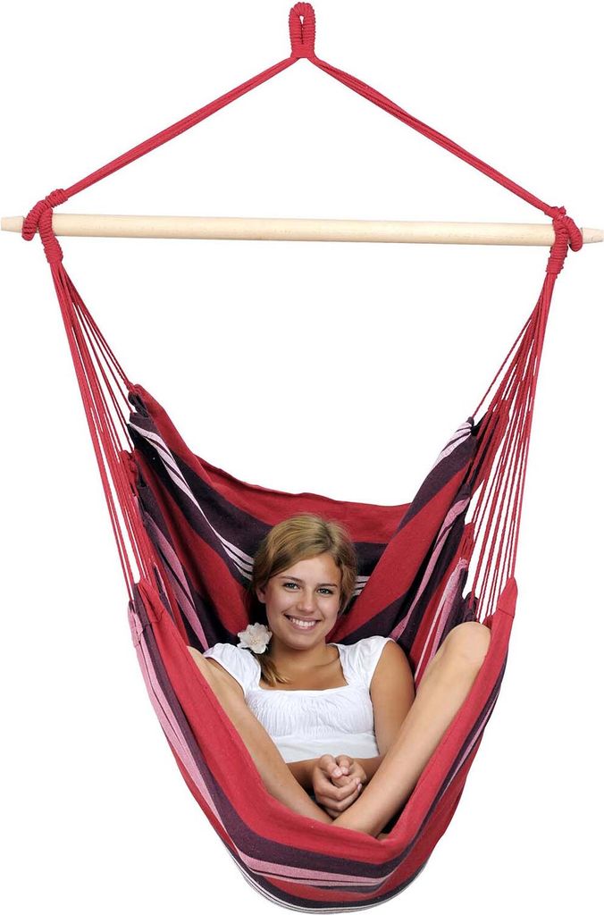 A woman is sitting in a striped hammock chair.