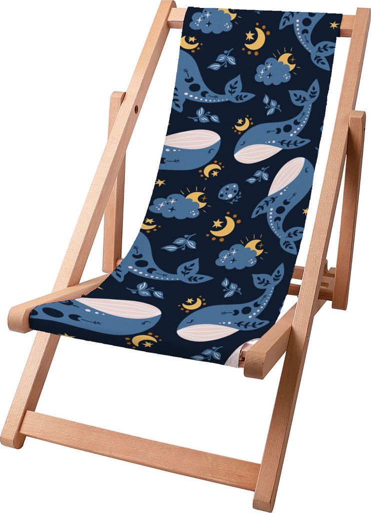 A wooden beach chair with a fabric seat featuring a pattern of whales, moons, and clouds.