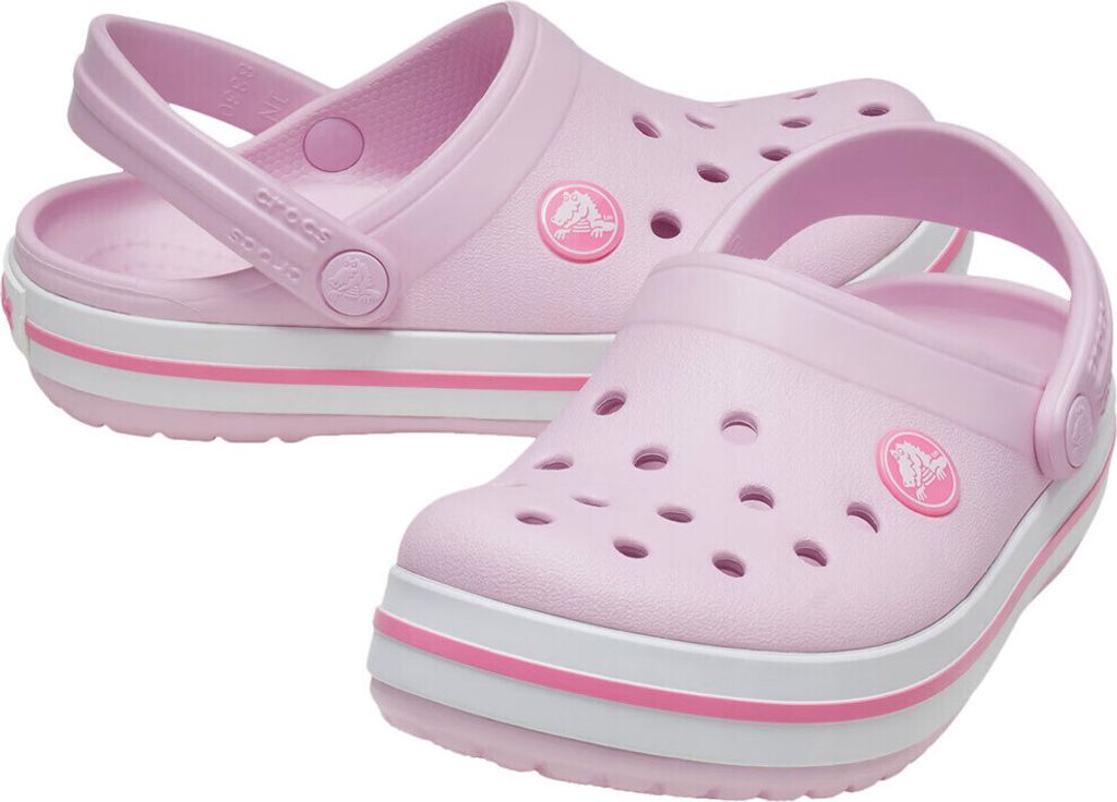 A pair of light pink Crocs with white and pink stripes on the sole, shown from a slightly elevated angle against a white background.