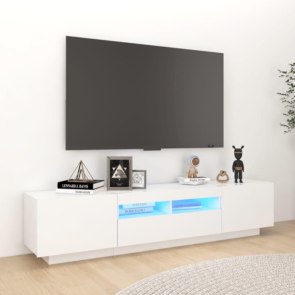 A white TV stand with a television on top, in a room with a white wall and wooden floor.