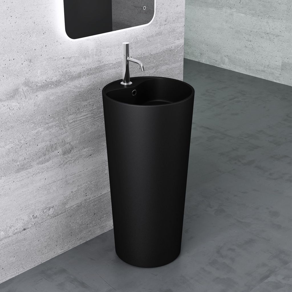 A black freestanding sink with a chrome faucet is shown in a modern bathroom with concrete walls and floor.