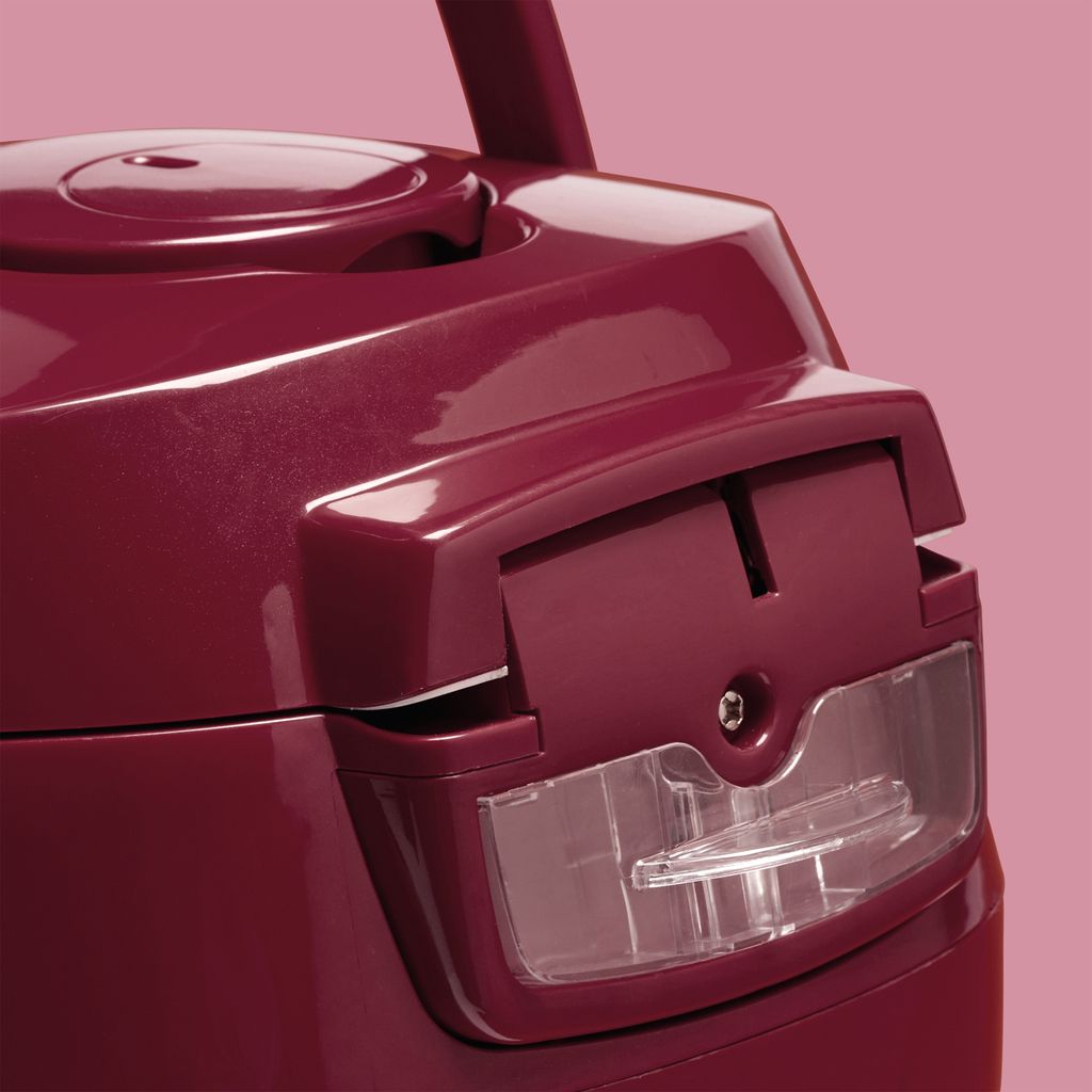 A close-up of a maroon kitchen appliance with a transparent window.