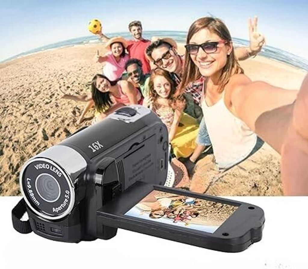 A group of friends taking a selfie on a beach with a camcorder.