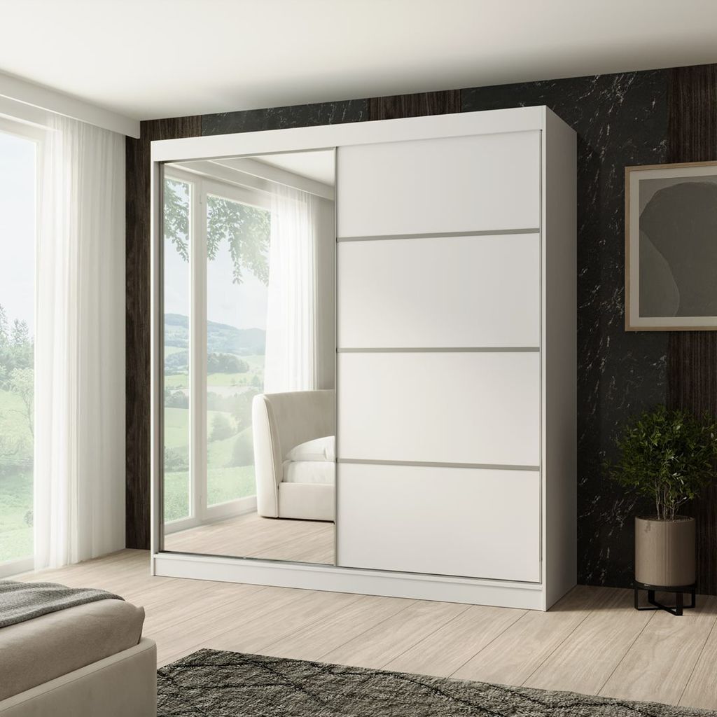 A white sliding door wardrobe with a mirrored door, placed in a bedroom setting with a window and a bed visible.