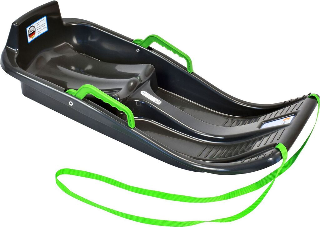 A dark gray plastic sled with green handles and a green rope, shown from a diagonal angle against a white background.