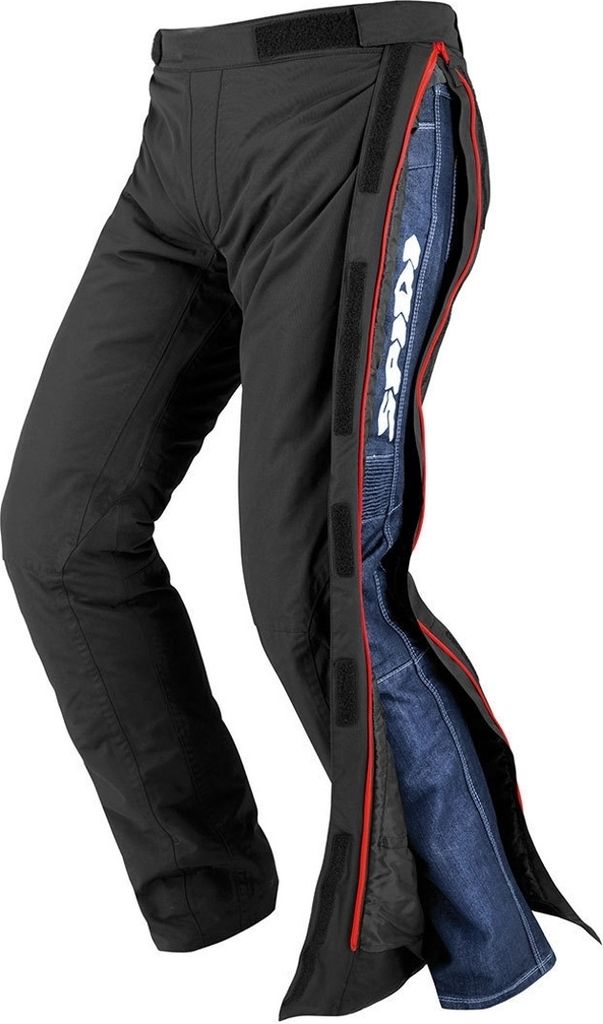 A pair of black motorcycle over-pants with blue jeans visible underneath.