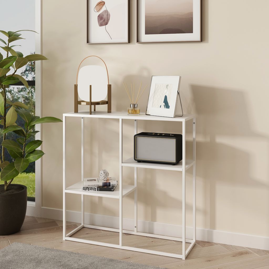 A white console table with three shelves is shown in a room setting, next to a window with a plant.