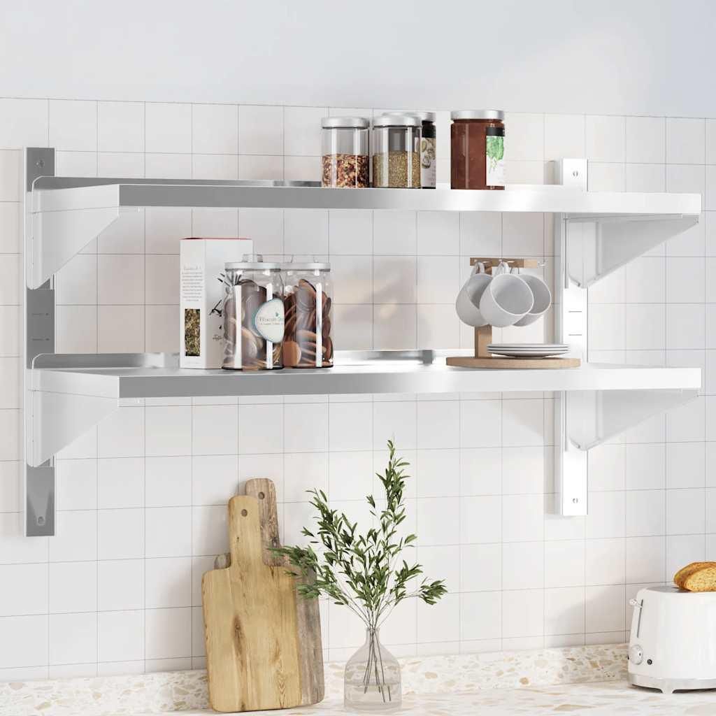 A kitchen counter with a tiled backsplash, featuring a two-tiered wall shelf holding various kitchen items.